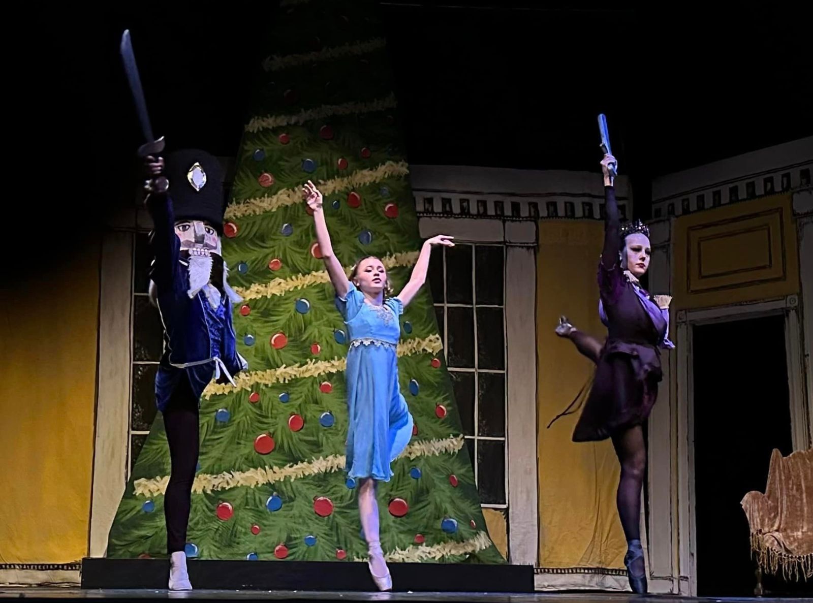 Three ballet dancers as The Nutcracker, Clara, and the Rat Queen in a scene from
